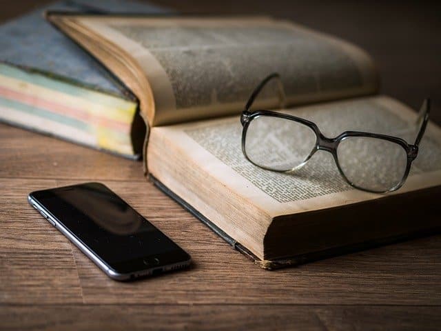 Libros, gafas y un móvil.