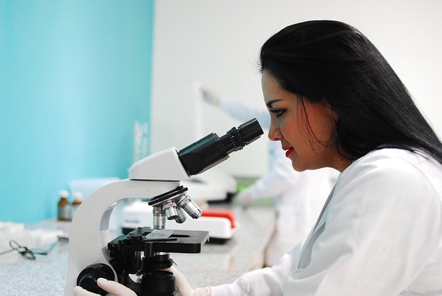 Mujer científica usando un microscopio