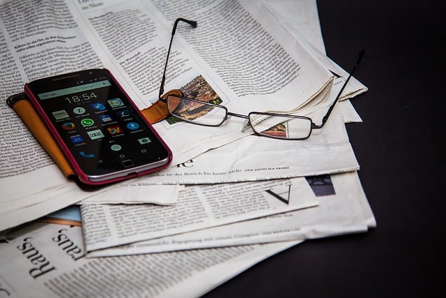 Periódicos, gafas y teléfono móvil