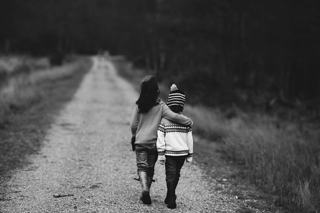 Dos niños caminando abrazados
