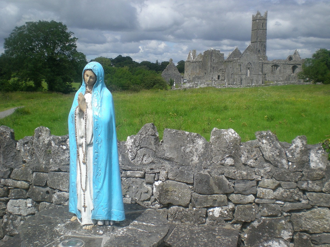Imagen de la Virgen María frente a un edificio antiguo