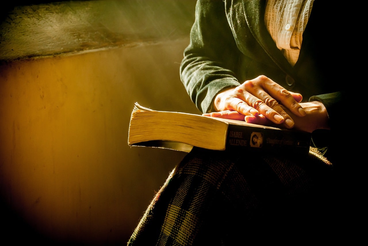 Mujer posando sus manos sobre la biblia