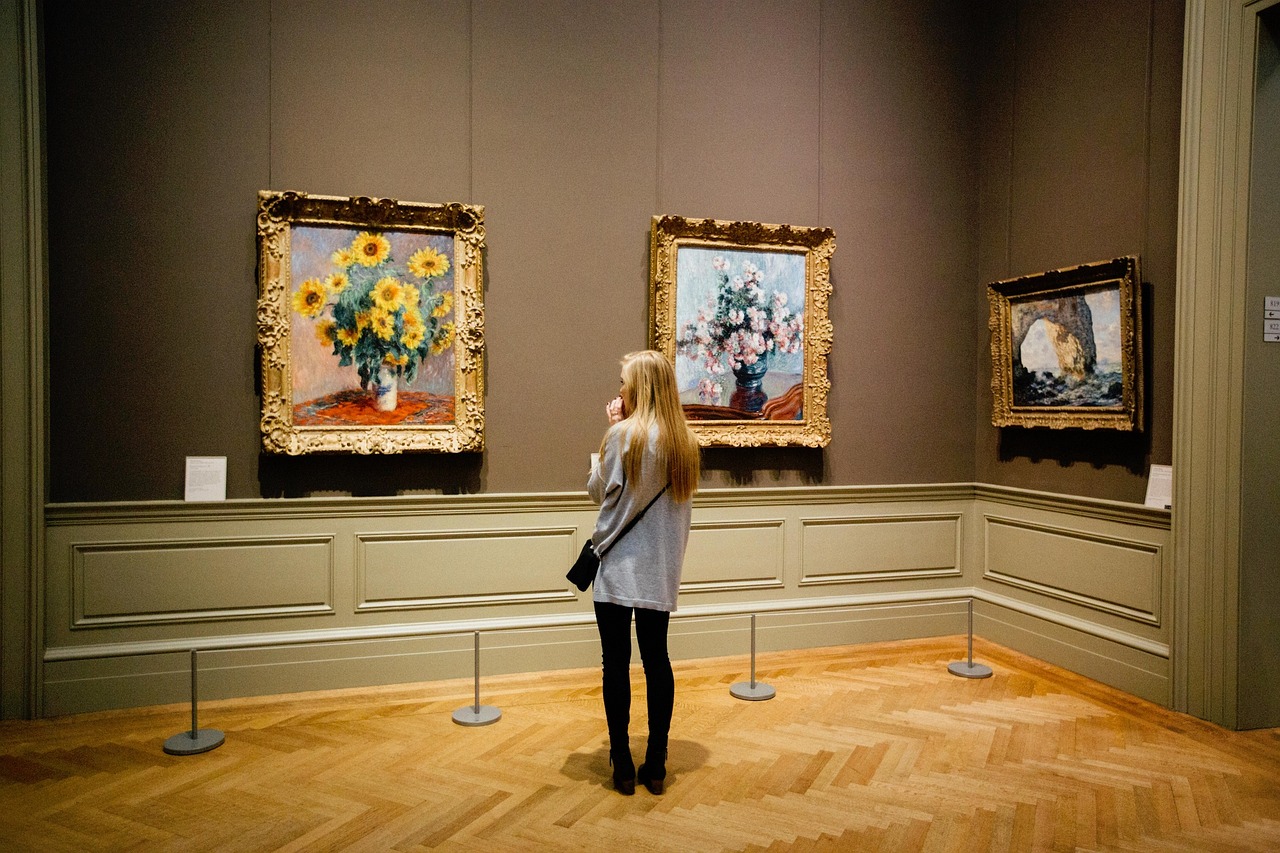Mujer mirando cuadros de flores en un museo