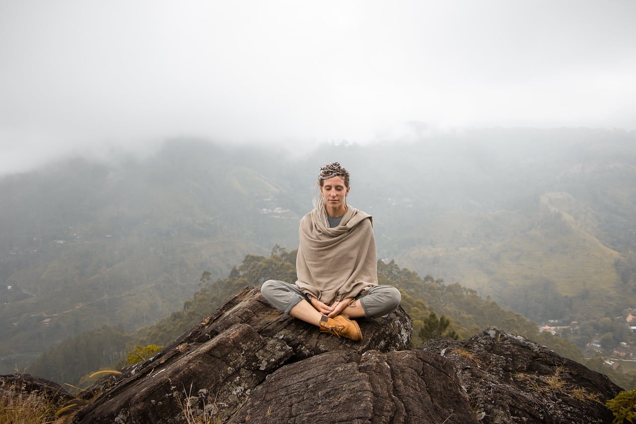 Mujer meditando sobre una montaña