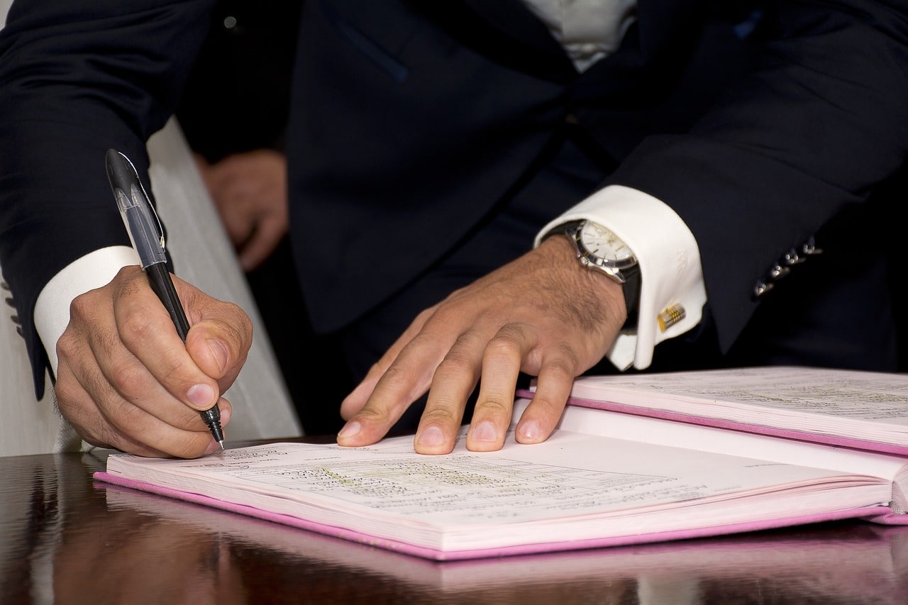 Hombre firmando un documento para certificar su validez