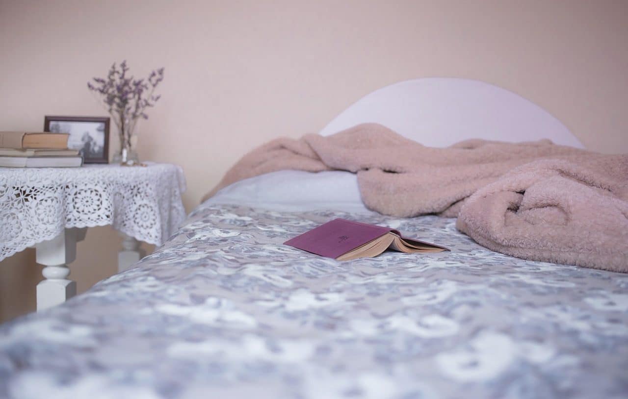 Libro y frazada sobre cama