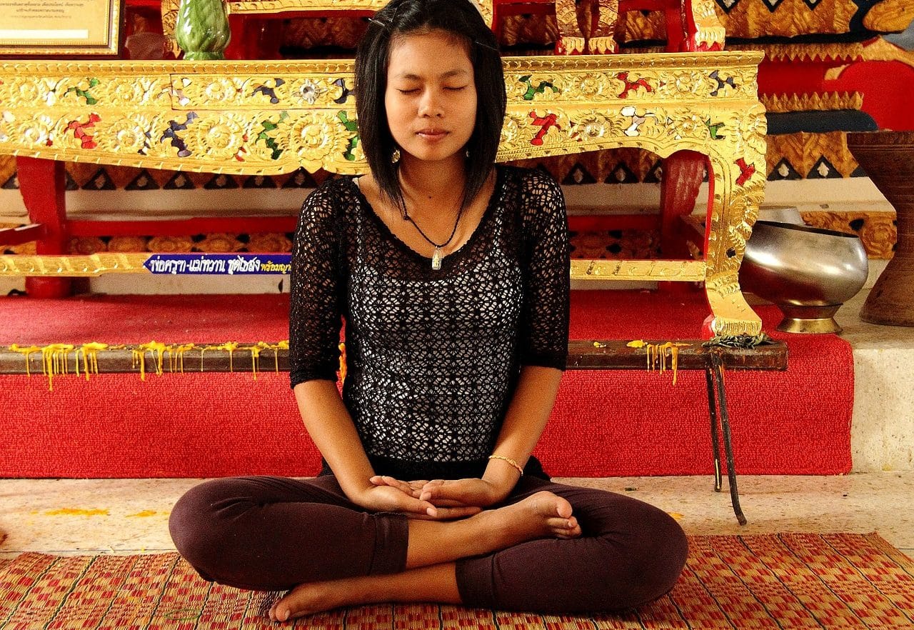 Mujer joven oriental haciendo meditación