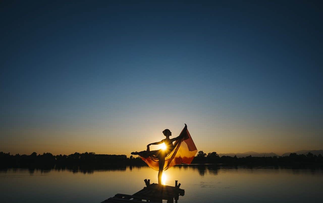 Mujer danzando frente a un lago