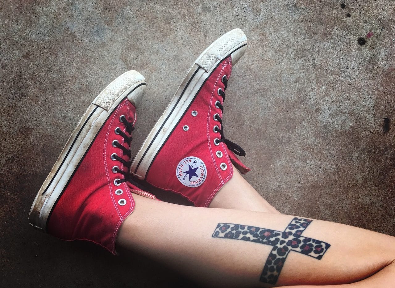 Tatuaje de una cruz en una pierna