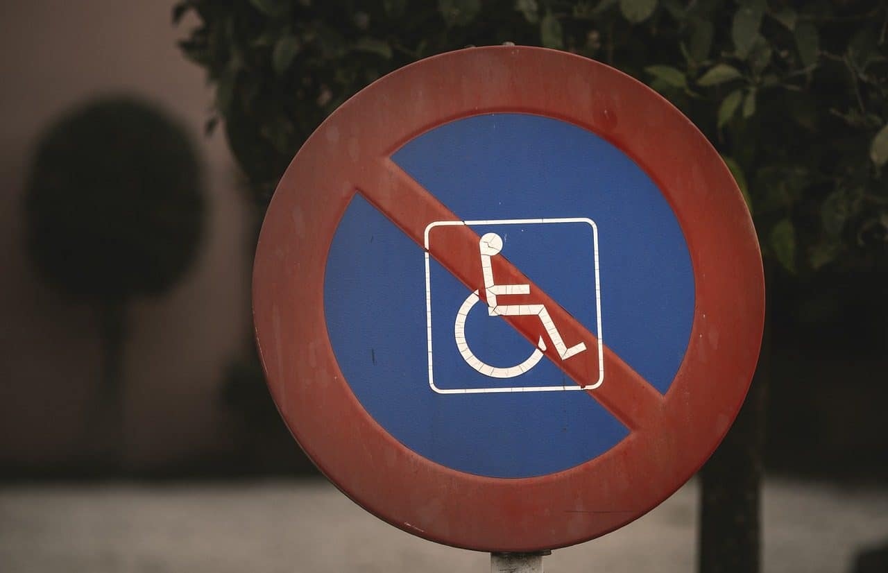 Cartel de prohibido estacionar con un icono de una persona en silla de ruedas