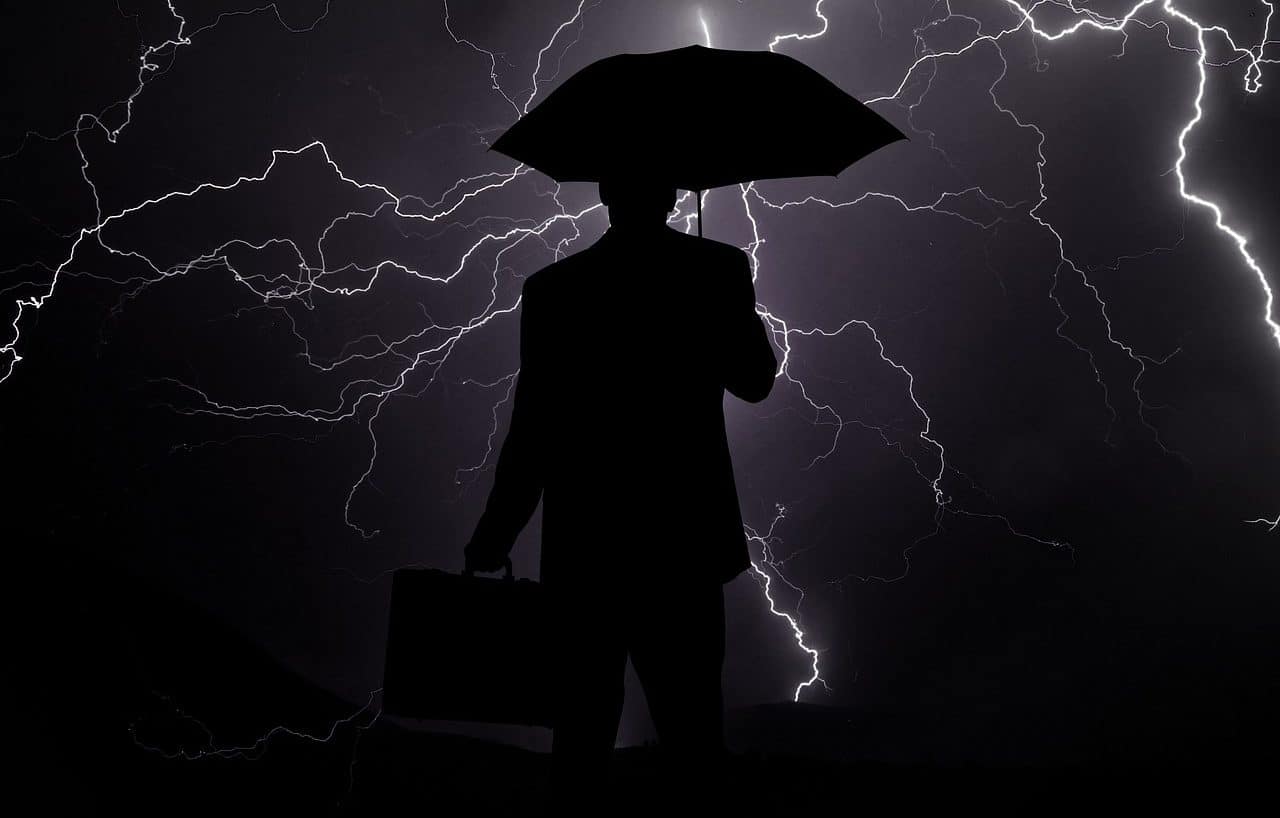 Hombre con paraguas bajo una tormenta eléctrica