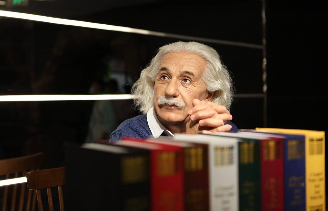 Albert Einstein sentado detrás de una fila de libros