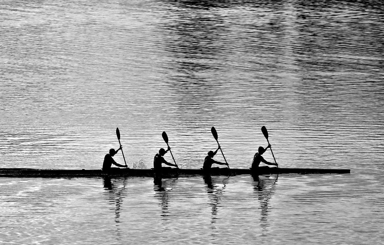 Cuatro personas en canoa, remando