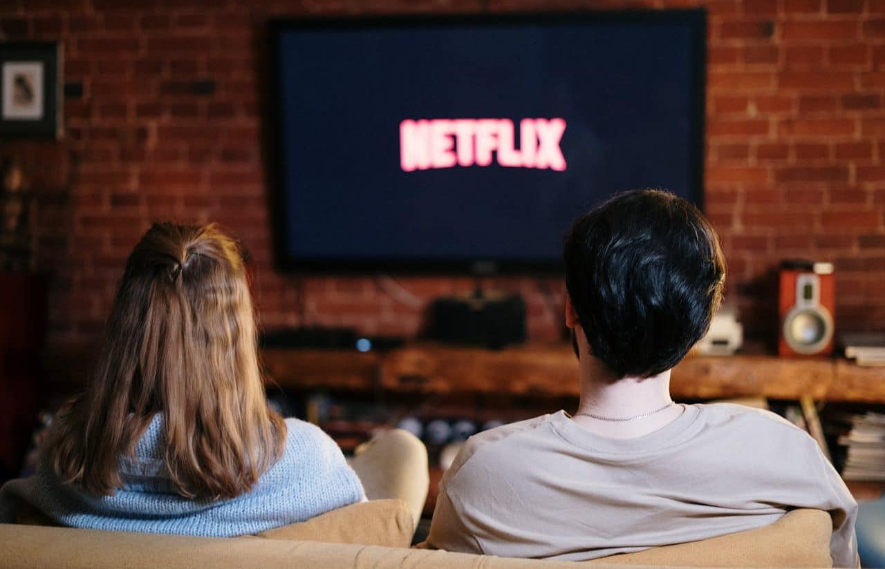 Mujer y hombre sentados en el sofá mirando Netflix