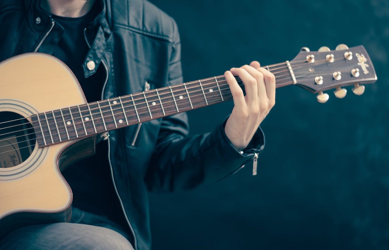 Persona joven tocando la guitarra.