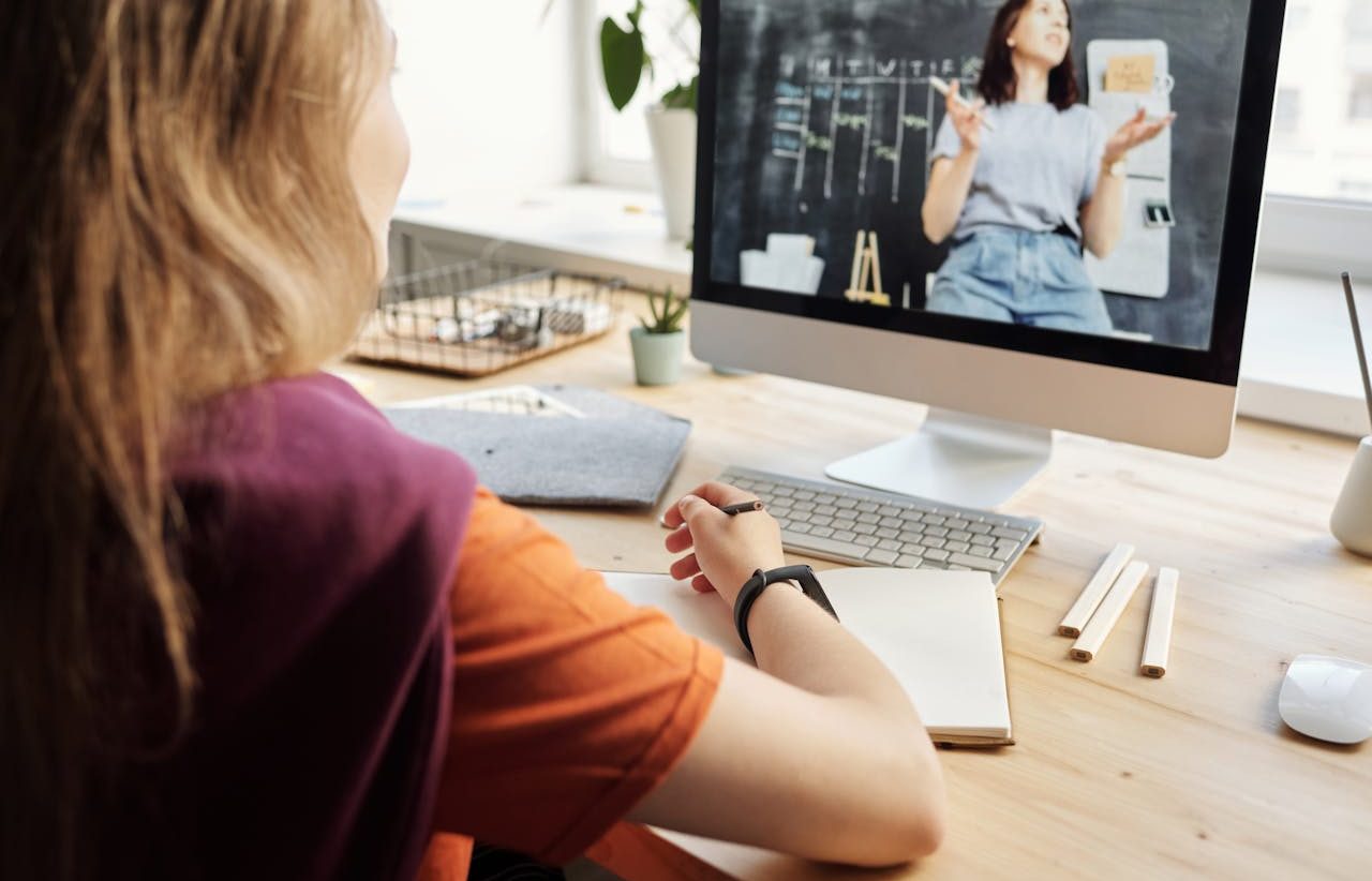 Muchacha tomando clases virtuales a través de una videollamada