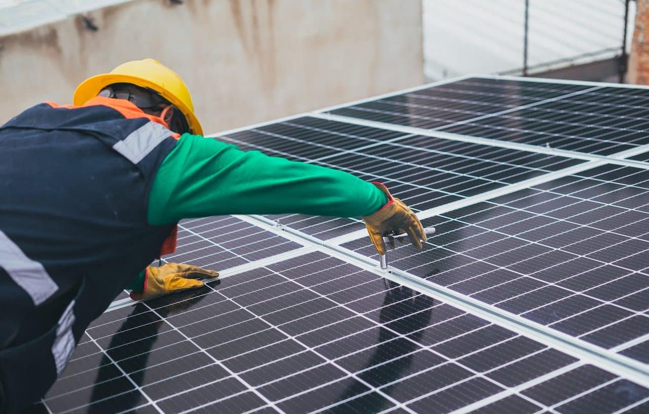 Hombre instalando paneles solares en un techo