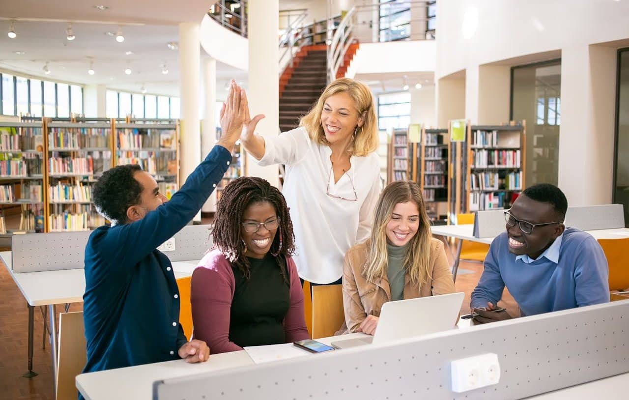 Mujer guidando a un grupo de estudio diverso en una biblioteca