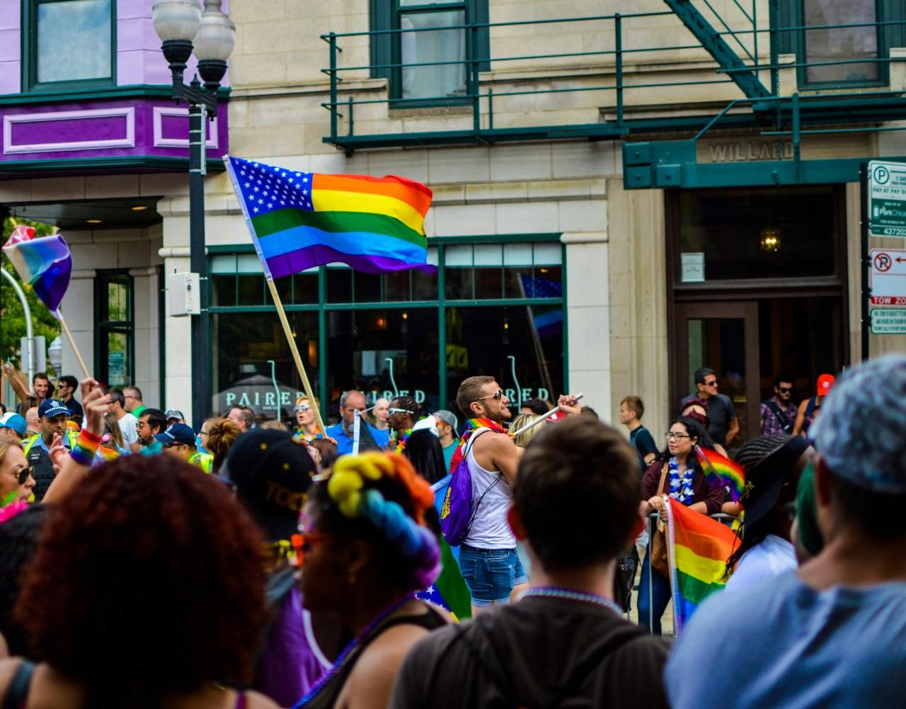 Marcha del orgullo LGBT+. Hombre ondeando la bandera del arcoíris