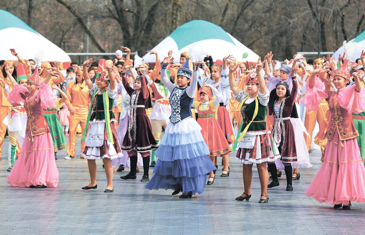 Festival comunitario. Mucha gente con atuendos tradicionales en un espacio público