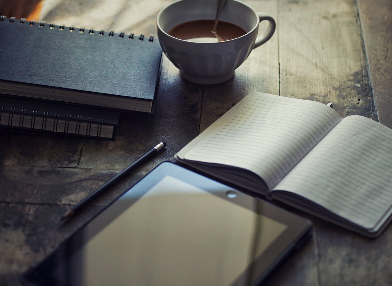 Diario personal y taza de té sobre un escritorio