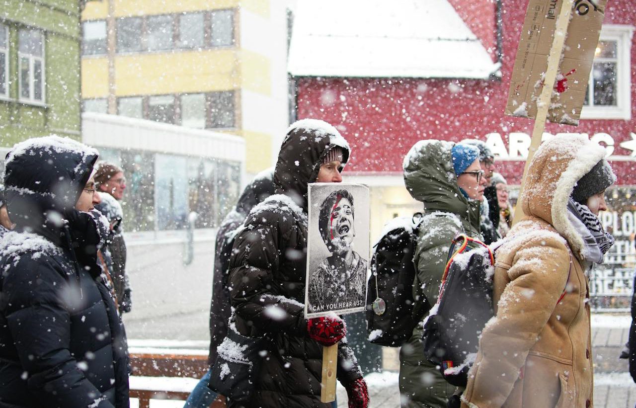 Protesta pacífica bajo la nieve. Personas llevando un retrato