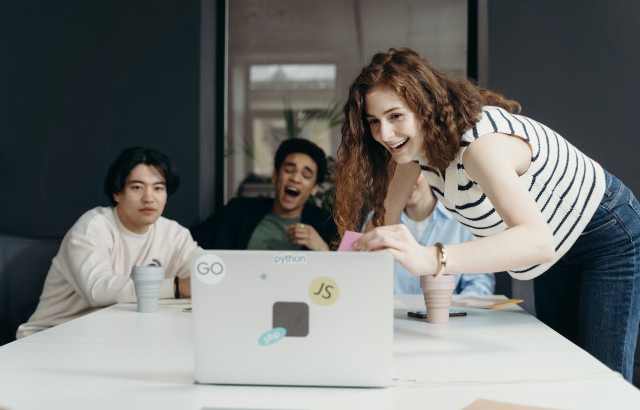 Varias personas trabajando frente a un ordenador portátil