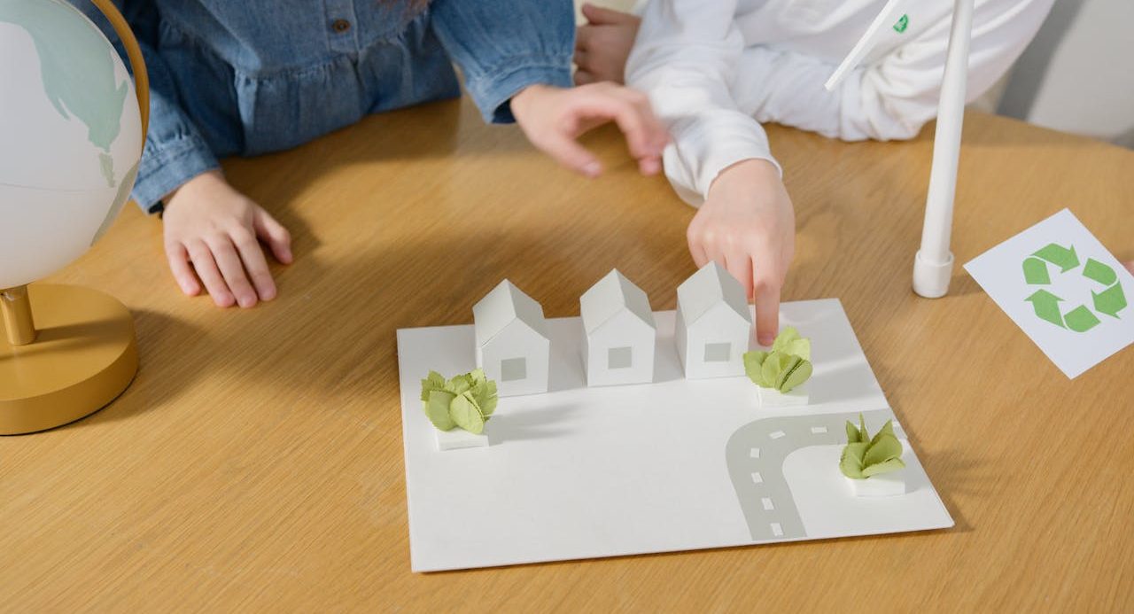 Niños usando una maqueta de un barrio urbano