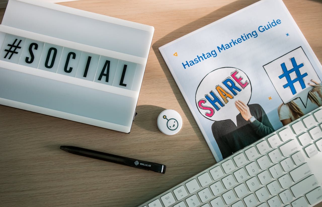 Teclado blanco y diferentes elementos de márketing viral, con palabras como "share" y hashtags