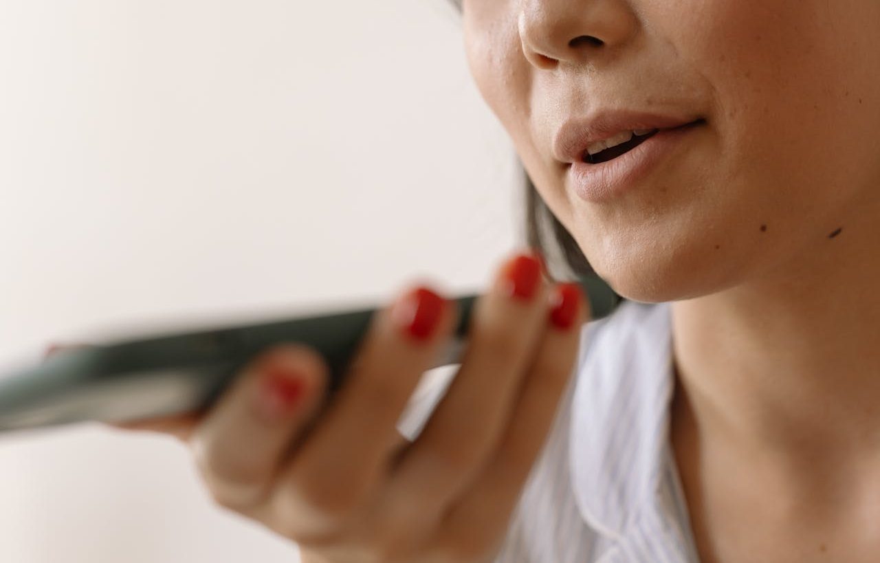 Mujer usando un asistente virtual en el teléfono