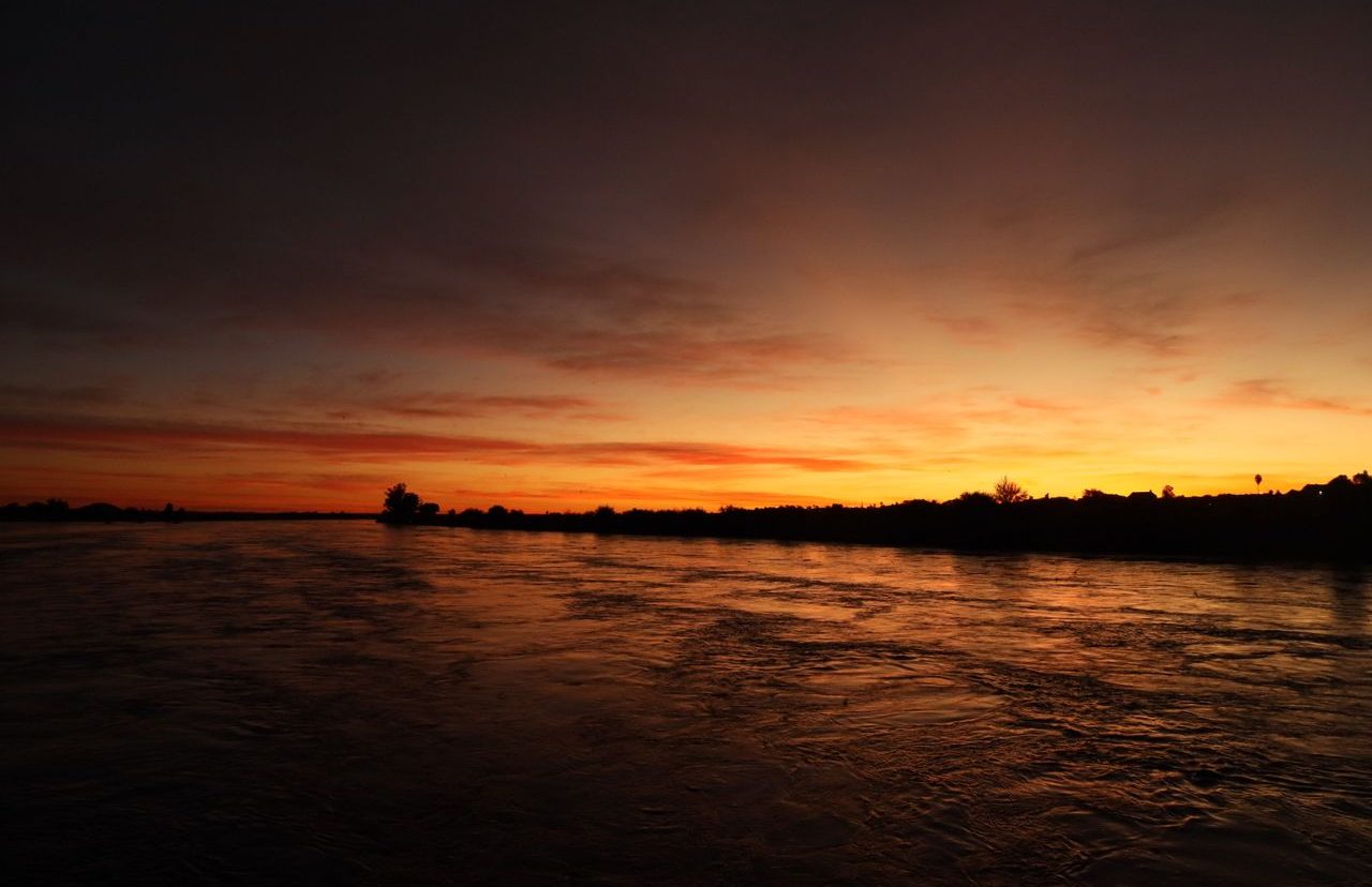 Puesta del sol, río